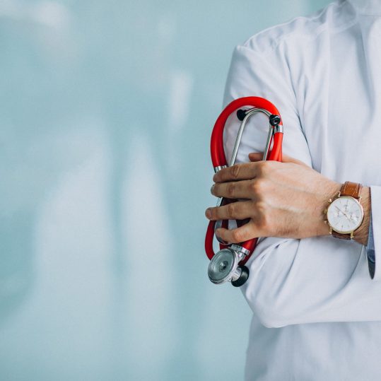 Young handsome physician in a medical robe with stethoscope